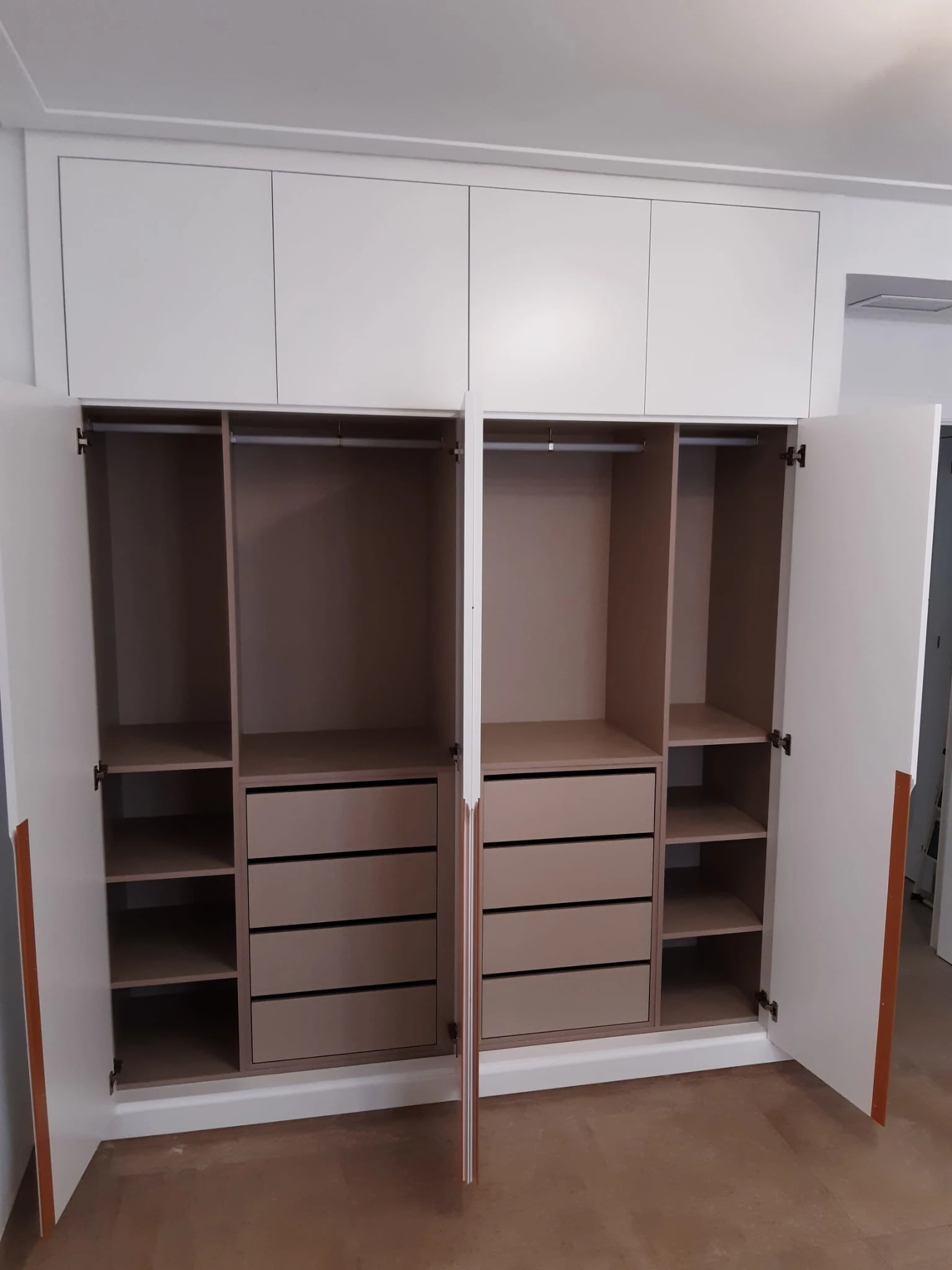 Interior de armario a medida con acabado efecto madera, cajonera y baldas en Sevilla
