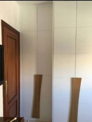 Armario a medida con dos profundidades adaptado para permitir la apertura de una puerta en Sevilla