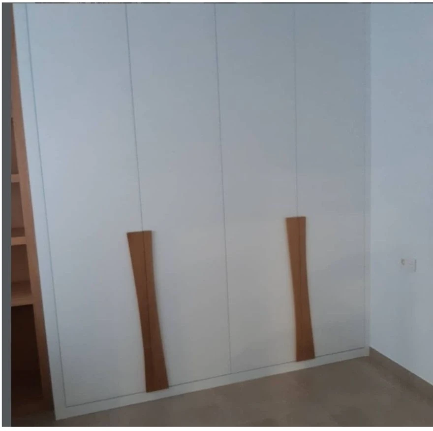 Armario blanco a medida con tiradores de madera y escritorio integrado